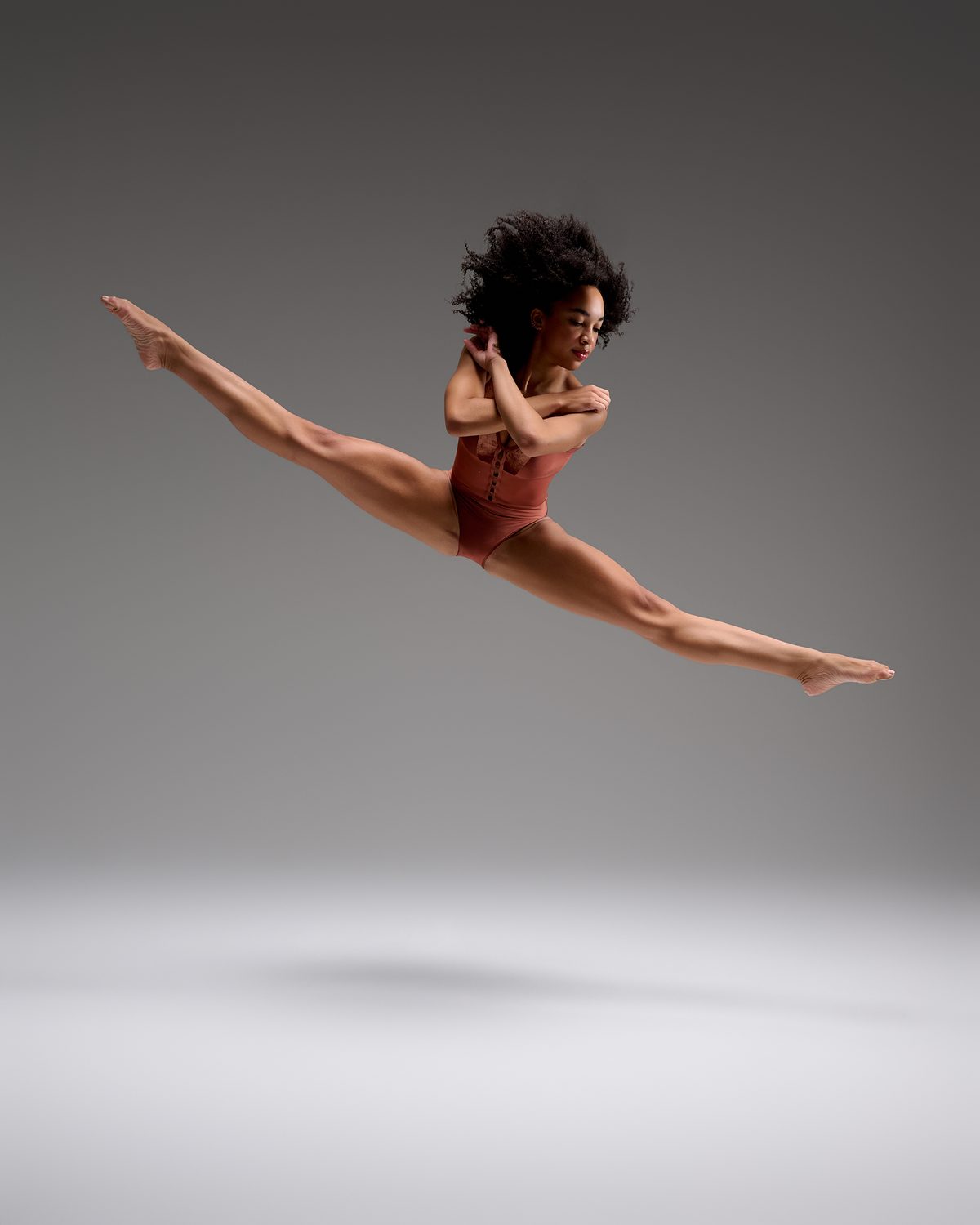 Marleigh McKay in a split leap with arms crossed